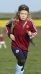 A child running across a field in rugby clothing